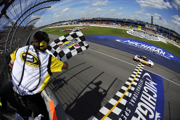 SIn this photo taken with a fisheye lens, Greg Biffle takes the checkered flag at the NASCAR Sprint Cup Series Quicken Loans 400 auto race at Michigan International Speedway, Sunday, June 16, 2013, in Brooklyn, Mich. (AP Photo/NASCAR, Jared C. Tilton, Pool)