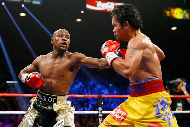 LAS VEGAS, NV - MAY 02:  Floyd Mayweather Jr. throws a left at Manny Pacquiao during their welterweight unification championship bout on May 2, 2015 at MGM Grand Garden Arena in Las Vegas, Nevada.  (Photo by Al Bello/Getty Images)