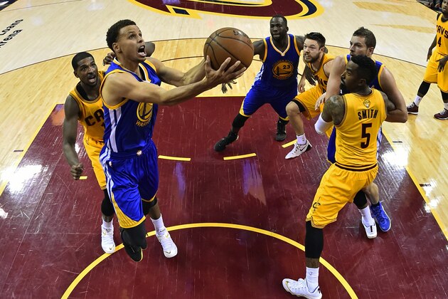 In this image made with a fisheye lens, Golden State Warriors guard Stephen Curry (30) shoots in front of Cleveland Cavaliers center Tristan Thompson (13) during the second half of Game 3 of basketball's NBA Finals in Cleveland, Tuesday, June 9, 2015. The Cavaliers defeated the Warriors 96-91. (Larry W. Smith/Pool Photo via AP)