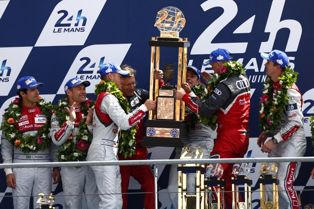 LE MANS, FRANCE - JUNE 15:  Winners of the 2014 Le Mans 24 Hour, Audi Sport Team Joest, Audi R18 E-Tron Quattro of Marcel Fassler, André Lotterer and Benoit Treluyer celebrate on the podium with Wolfgang Ullrich of Austria, Head of Audi Motorsport on June 15, 2014 in Le Mans, France.  (Photo by Andrew Hone/Getty Images)