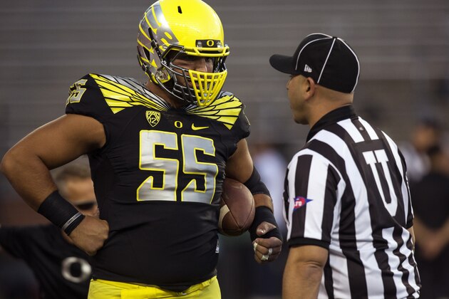 FILE - In this Sept. 20, 2014, file photo, Oregon center Hroniss Grasu (55) talks with umpire Rosco Meisenheimer before the start of an NCAA college football game against Washington State in Pullman, Wash. While quarterback Marcus Mariota is the unquestioned leader of the team, Grasu is its anchor. (AP Photo/Dean Hare, File)