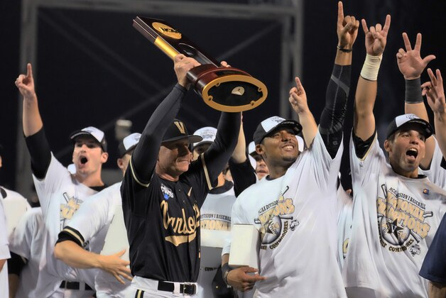 Vanderbilt coach Tim Corbin holds the trophy as he celebrates with his players after Vanderbilt defeated Virginia 3-2 in the deciding game of the best-of-three NCAA baseball College World Series finals in Omaha, Neb., Wednesday, June 25, 2014. (AP Photo/Eric Francis)