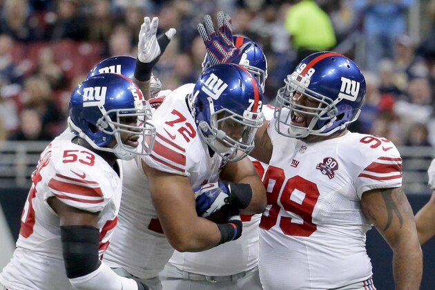 New York Giants defensive end Kerry Wynn (72) is congratulated by teammates after intercepting a pass during the first half of an NFL football game against the St. Louis Rams Sunday, Dec. 21, 2014, in St. Louis. (AP Photo/Charlie Riedel)