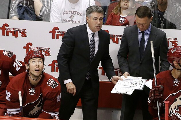 Arizona Coyotes coach Dave Tippett, middle, hands the clipboard to assistant coach Newell Brown as Coyotes' David Moss, left, looks at the scoreboard during the third period of an NHL hockey game against the Anaheim Ducks Saturday, April 11, 2015, in Glendale, Ariz. The Ducks defeated the Coyotes 2-1. (AP Photo/Ross D. Franklin)