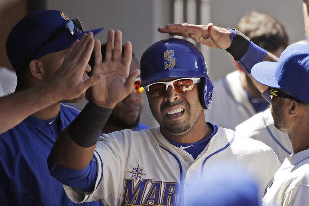Seattle Mariners' Nelson Cruz is congratulated after scoring in a baseball game against the Tampa Bay Rays Sunday, June 7, 2015, in Seattle. (AP Photo/Elaine Thompson)