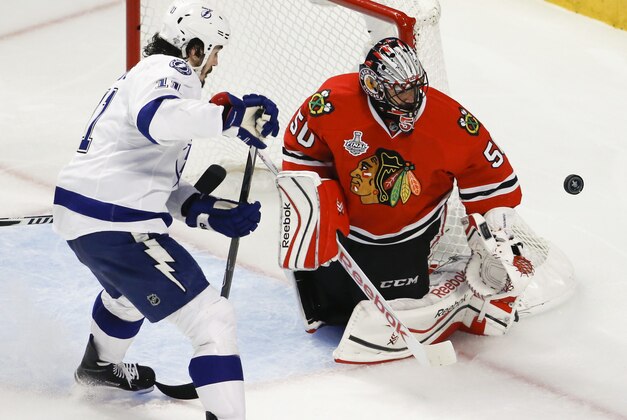 Chicago Blackhawks goalie Corey Crawford, right, deflects a puck as Tampa Bay Lightning's Brian Boyle watches during the third period in Game 4 of the NHL hockey Stanley Cup Final Wednesday, June 10, 2015, in Chicago. (AP Photo/Charles Rex Arbogast)