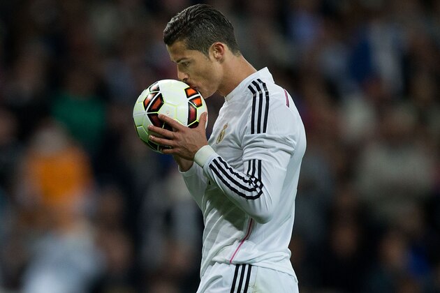 MADRID, SPAIN - APRIL 18:  Cristiano Ronaldo of Real Madrid CF kisses the ball before striking a penalty shot during the La Liga match between Real Madrid CF and Malaga CF at Estadio Santiago Bernabeu on April 18, 2015 in Madrid, Spain.  (Photo by Gonzalo Arroyo Moreno/Getty Images)