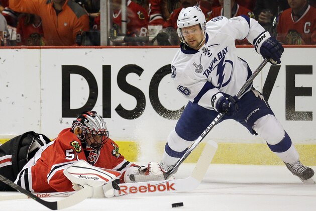 Chicago Blackhawks goalie Corey Crawford, left, and Tampa Bay Lightning's Anton Stralman watch a loose puck during the first period in Game 4 of the NHL hockey Stanley Cup Final Wednesday, June 10, 2015, in Chicago. (AP Photo/Nam Y. Huh)