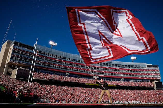 LINCOLN, NE - OCTOBER 25: A flag bearer for the Nebraska Cornhuskers waves a flag after the first score during the game against the Rutgers Scarlet Knights at Memorial Stadium on October 25, 2014 in Lincoln, Nebraska. Nebraska defeated Rutgers 42-24. (Photo by Eric Francis/Getty Images)