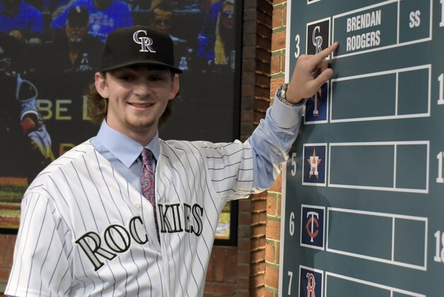 Shortstop Brendan Rodgers from Lake Mary High School in Longwood, Fla., points to his name on the board after being selected by the Colorado Rockies with the third selection at the 2015 MLB baseball draft Monday, June 8, 2015, in Secaucus, N.J.  (AP Photo/Bill Kostroun)