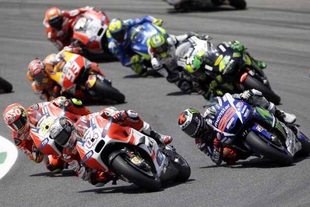 Jorge Lorenzo, right, steers his Yamaha past  Ducati's rider Andrea Dovizioso, center, and Ducati's rider Andrea Iannone, left, during the Italian MotoGP, at the Mugello race circuit, in Scarperia, Italy, Sunday, May 31, 2015. Jorge Lorenzo won the race ahead of Italy's Andrea Iannone and Italy's Valentino Rossi. (AP Photo/Gregorio Borgia)