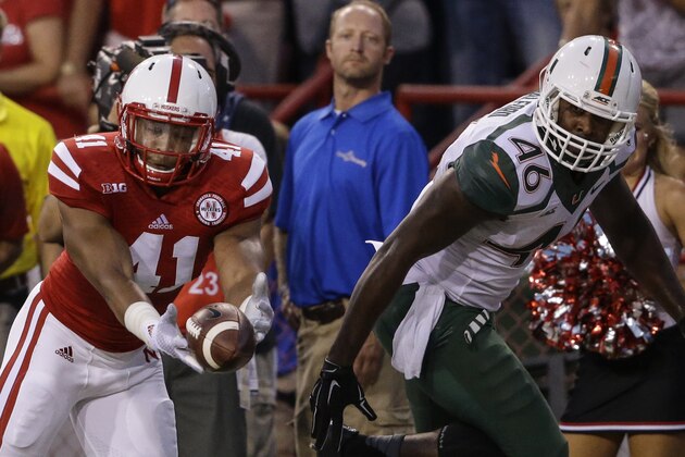 Nebraska linebacker David Santos (41) intercepts a pass intended for Miami tight end Clive Walford (46) for a turnover in the first half of an NCAA college football game in Lincoln, Neb., Saturday, Sept. 20, 2014. (AP Photo/Nati Harnik)