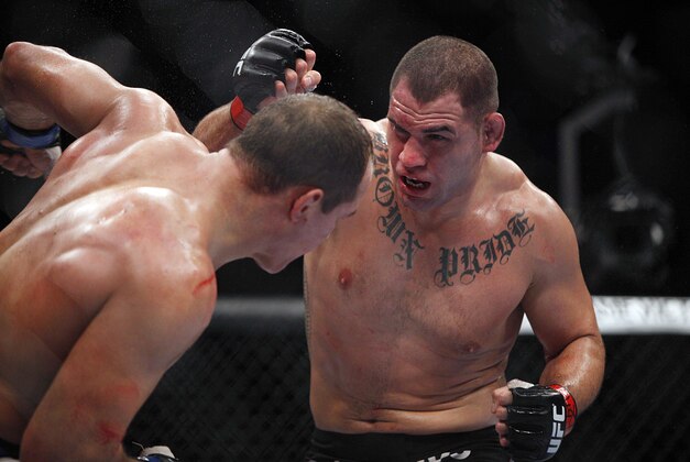 Oct 19, 2013; Houston, TX, USA; Cain Velasquez (red gloves) fights against Junior Dos Santos (blue gloves) in the world heavyweight championship bout during UFC 166 at Toyota Center. Mandatory Credit: Andrew Richardson-USA TODAY Sports