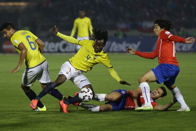 Ecuador's Juan Carlos Paredes, center, fights for the ball against Chile's Alexis Sanchez, bottom, during a Copa America Group 1 soccer match at the National Stadium in Santiago, Chile, Thursday, June 11, 2015.(AP Photo/Ricardo Mazalan)