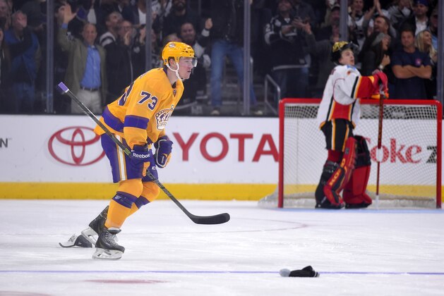Los Angeles Kings center Tyler Toffoli, left, skates off as hats land on the ice after scoring as Calgary Flames goalie Jonas Hiller, of Switzerland, watches during the third period of an NHL hockey game, Thursday, Feb. 12, 2015, in Los Angeles. The goal was third for Tyler Toffoli in the game. The Kings won 5-3. (AP Photo/Mark J. Terrill)