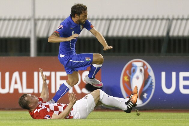 Italy's Claudio Marchisio, top, is tackled by Croatia's Ivica Olic during the Euro 2016 Group H qualifying soccer match between Croatia and Italy, in Split, Croatia, Friday, June 12, 2015. (AP Photo/Darko Bandic)