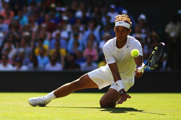 LONDON, ENGLAND - JUNE 24:  Rafael Nadal of Spain plays the ball as he takes a tumble during his Gentlemen's Singles first round match against Martin Klizan of Slovakia on day two of the Wimbledon Lawn Tennis Championships at the All England Lawn Tennis and Croquet Club at Wimbledon on June 24, 2014 in London, England.  (Photo by Al Bello/Getty Images)