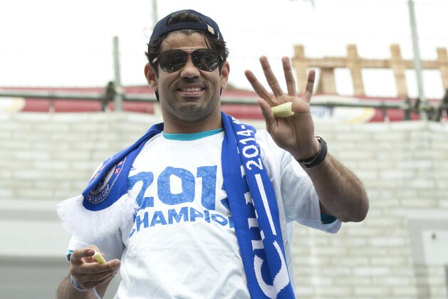 Chelsea's Diego Costa waves to the crowds as the team parade through the streets near their Stamford Bridge stadium in London Monday, May 25, 2015. Chelsea won the English Premier League title for 2014/15 as well as the League Cup, with both trophies on display. (AP Photo/Alastair Grant)