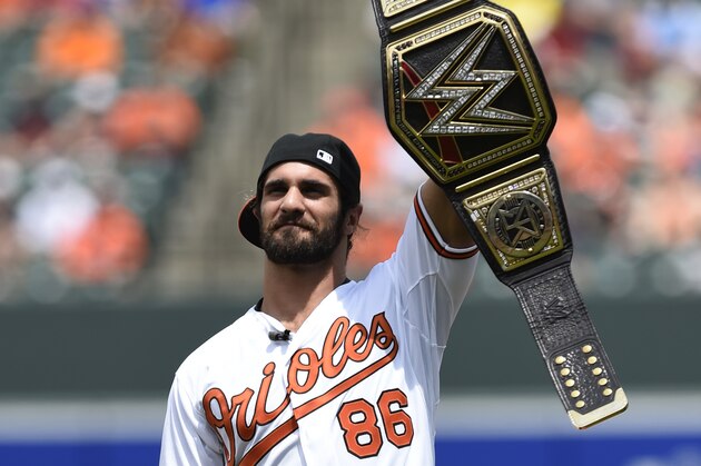 WWE world heavyweight champion Seth Rollins addresses the crowd before throwing out the ceremonial first pitch before the Baltimore Orioles and Los Angeles Angels baseball game, Sunday, May 17, 2015 in Baltimore. (AP Photo/Gail Burton)