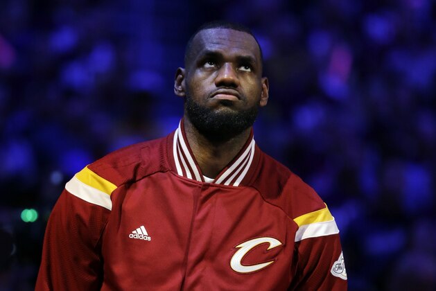 Cleveland Cavaliers forward LeBron James listens to the nation anthem before Game 3 of basketball's NBA Finals against the Golden State Warriors in Cleveland, Tuesday, June 9, 2015. (AP Photo/Tony Dejak)