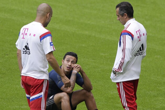Bayern Munich head coach Pep Guardiola of Spain, left, talks to Thiago Alcantara of Spain during a training session after an official team presentation in the Allianz Arena stadium for the new German first division Bundesliga soccer season, in Munich, southern Germany, Saturday, Aug. 9, 2014. 65,000 spectators attended the event. (AP Photo/Matthias Schrader)