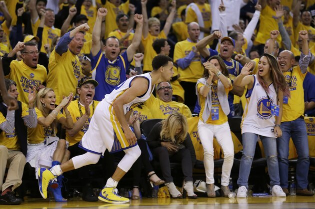 FILE - In this May 19, 2015, file photo, fans cheer after Golden State Warriors guard Stephen Curry scored against the Houston Rockets during the second half of Game 1 of the NBA basketball Western Conference finals in Oakland, Calif. It has been 40 years since Golden State's loud and loyal fans could experience the NBA Finals. After decades of bad drafts, terrible trades and lots of losses, the most hardened Warriors’ supporters are soaking in every second of this run.  After all, many have waited their entire lives to experience this moment. (AP Photo/Ben Margot, File)