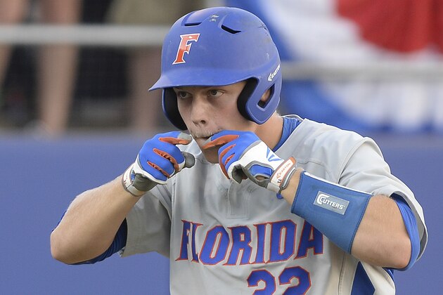 Florida catcher JJ Schwarz (22) does a little lip guesture after he crossed home plate following his homerun during the sixth inning of an NCAA college baseball super regional tournament against George State in Gainesville, Fla., Saturday, June, 6, 2015. Florida defeated Florida State 11-4.  (AP Photo/Phil Sandlin)