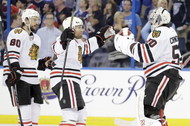 Chicago Blackhawks goalie Corey Crawford (50) is congratulated by center Antoine Vermette (80) and defenseman Kimmo Timonen (44) after the Blackhawks beat the Tampa Bay Lightning 2-1 in Game 5 of the NHL hockey Stanley Cup Final, Saturday, June 13, 2015, in Tampa, Fla. (AP Photo/Chris O'Meara)