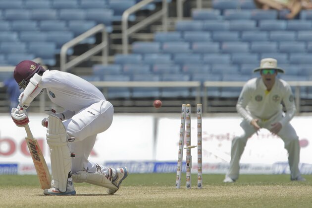West Indies' Shai Hope, left, reacts after being bowled by Australia's Mitchell Johnson for 16 runs, during the second innings on the fourth day of their second cricket Test match in Kingston, Jamaica, Sunday, June 14, 2015. (AP Photo/Arnulfo Franco)