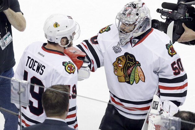 Chicago Blackhawks goalie Corey Crawford (50) greets center Jonathan Toews (19) after the Blackhawks beat the Tampa Bay Lightning 2-1 in Game 5 of the NHL hockey Stanley Cup Final, Saturday, June 13, 2015, in Tampa, Fla. (AP Photo/John Raoux)