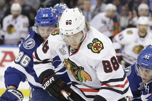 Chicago Blackhawks right wing Patrick Kane (88), middle, tries to move the puck away from Tampa Bay Lightning right wing Nikita Kucherov (86), left, of Russia and center Valtteri Filppula (51) of Finland, during the second period in Game 1 of the NHL hockey Stanley Cup Final in Tampa, Fla., Wednesday, June 3, 2015.  (AP Photo/Chris O'Meara)