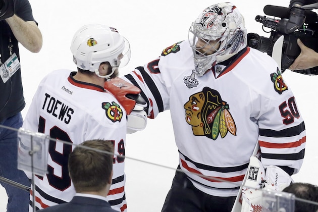 Chicago Blackhawks goalie Corey Crawford (50) greets center Jonathan Toews (19) after the Blackhawks beat the Tampa Bay Lightning 2-1 in Game 5 of the NHL hockey Stanley Cup Final, Saturday, June 13, 2015, in Tampa, Fla. (AP Photo/John Raoux)