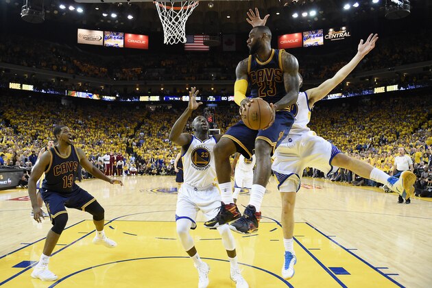 Cleveland Cavaliers forward LeBron James, top, looks to pass against the Golden State Warriors during the second half of Game 5 of basketball's NBA Finals in Oakland, Calif., Sunday, June 14, 2015. The Warriors won 104-91. (Bob Donnan/USA TODAY Sports Pool via AP)