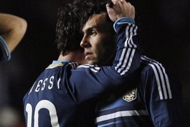 ALTERNATIVE CROP OF XDJ219 - Argentina's Carlos Tevez, right, is consoled by teammate Lionel Messi after missing to score his penalty kick during the penalty shootout of the Copa America quarterfinal soccer match against Uruguay in Santa Fe, Argentina, Saturday, July 16, 2011. Uruguay advanced to the semifinals with a 5-4 victory over Argentina on penalties after a 1-1 draw. (AP Photo/Natacha Pisarenko)