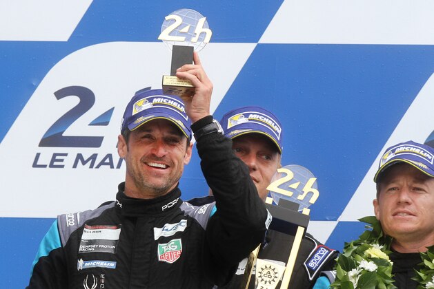 US actor Patrick Dempsey celebrates during the 83rd 24-hour Le Mans endurance race podium ceremony of the LM GTE AM category, as his team finished at the second place, in Le Mans, western France, Sunday, June 14, 2015. (AP Photo/David Vincent)