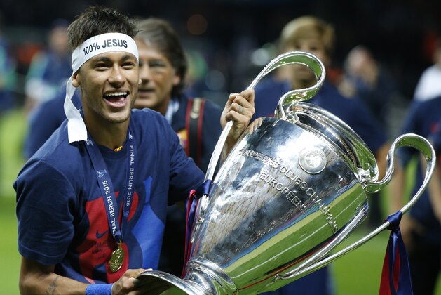 Barcelona's Neymar celebrates with the trophy after the Champions League final soccer match between Juventus Turin and FC Barcelona at the Olympic stadium in Berlin Saturday, June 6, 2015. Barcelona won the match 3-1.   (AP Photo/Luca Bruno)