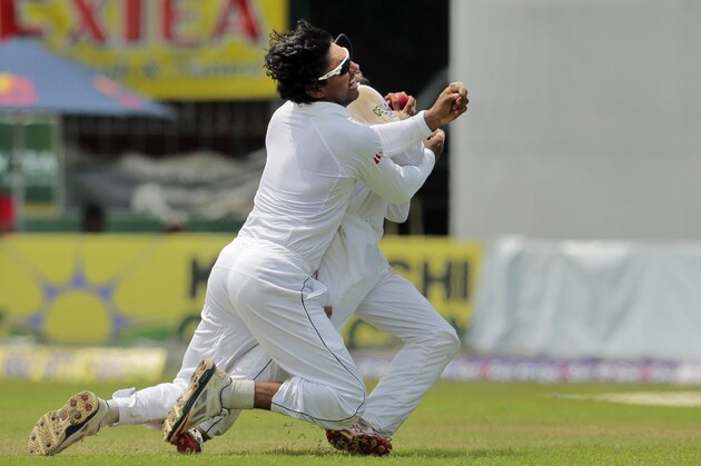 Sri Lanka's Kumar Sangakkara, left, collides with Kaushal Silva in an attempt to catch the ball to dismiss Pakistan's Saeed Ajmal in their second test cricket match in Colombo, Sri Lanka, Monday, Aug. 18, 2014. Sri Lanka won by 105 runs. (AP Photo/Eranga Jayawardena)