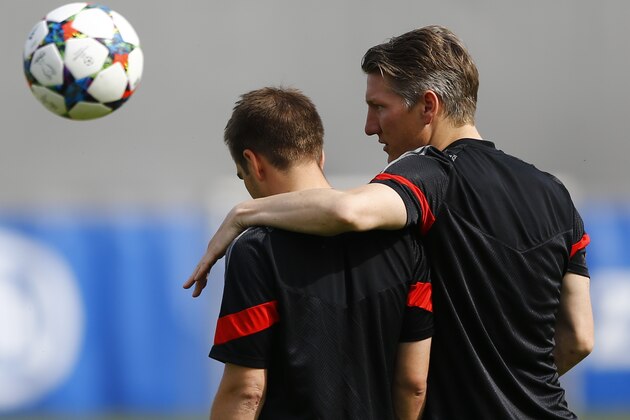 Bayern's Bastian Schweinsteiger, right, embraces teammate Philipp Lahm during a training session in Munich, southern Germany, Monday, May 11, 2015. FC Bayern Munich will play against FC Barcelona in a second leg semifinal Champions League soccer match on Tuesday. (AP Photo/Matthias Schrader)