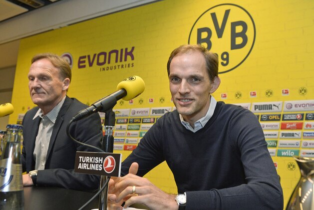 Borussia Dortmund's new head coach Thomas Tuchel, right, sits beside CEO Hans-Joachim Watzke, left, under the club logo at his first press conference at the stadium in Dortmund, Germany, Wednesday, June 3, 2015. Tuchel follows Juergen Klopp, who left the German first division soccer club BVB after seven years. (AP Photo/Martin Meissner)