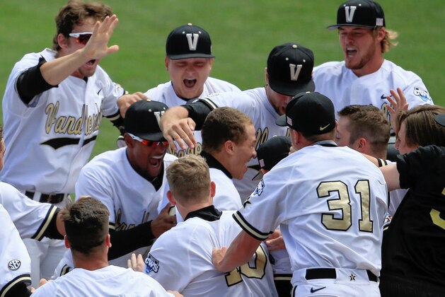 Vanderbilt players mob Jeren Kendall, center, after he hit the game-winning two-run home run in the bottom of the ninth inning of an NCAA College World Series baseball game against Cal State Fullerton at TD Ameritrade Park in Omaha, Neb., Monday, June 15, 2015. Vanderbilt won 4-3. (AP Photo/Nati Harnik)