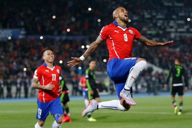 Chile's Arturo Vidal, right, celebrates after scoring against Mexico during a Copa America Group A soccer match at El Nacional stadium in Santiago, Chile, Monday, June 15, 2015. The player at the left is Eduardo Vargas . (AP Photo/Silvia Izquierdo)