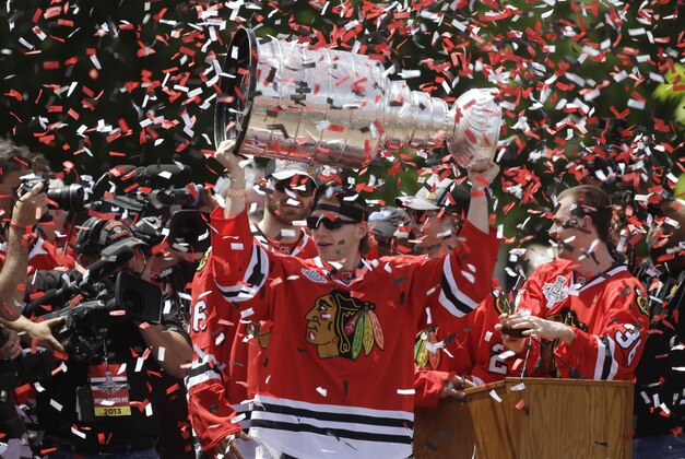 Chicago Blackhawks right wing Patrick Kane (88) holds up the Stanley Cup Trophy during a rally in Grant Park for the NHL Stanley Cup hockey champions Friday, June 28, 2013, in Chicago. (AP Photo/M. Spencer Green)