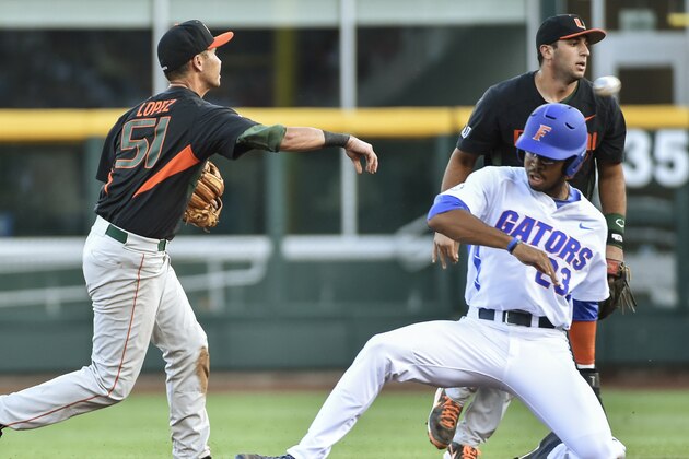 Florida's Buddy Reed (23) is forced out at second base as Miami shortstop Brandon Lopez (51) throws to first base for a double play, during the second inning of an NCAA College World Series baseball game in Omaha, Neb., Saturday, June 13, 2015. (AP Photo/Mike Theiler)