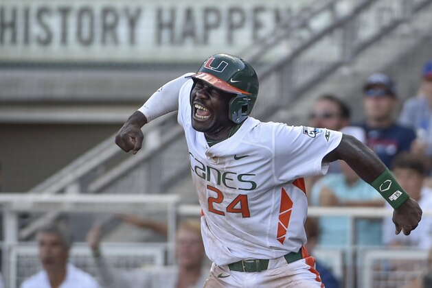 Miami's Jacob Heyward (24) celebrates a go-ahead run after a series of throwing errors by Arkansas, in the seventh inning of an NCAA College World Series baseball elimination game at TD Ameritrade Park in Omaha, Neb., Monday, June 15, 2015. (AP Photo/Mike Theiler)