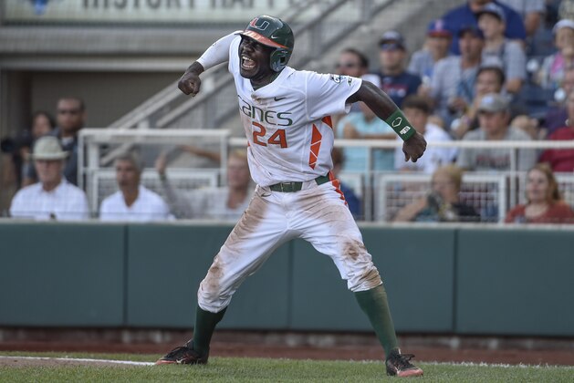 Miami's Jacob Heyward celebrates a go-ahead run after a series of throwing errors by Arkansas, in the seventh inning of an NCAA College World Series baseball elimination game in Omaha, Neb., Monday, June 15, 2015. (AP Photo/Mike Theiler)