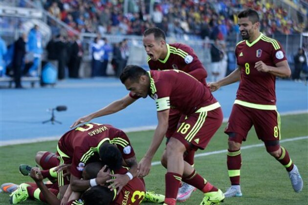 Venezuela's Jose Rondon, ground, is congratulated by his teammates after scoring a goal against Colombia during a Copa America Group C soccer match at El Teniente stadium in Rancagua, Chile, Sunday, June 14, 2015. Venezuela won the match 1-0. (AP Photo/Ricardo Mazalan)