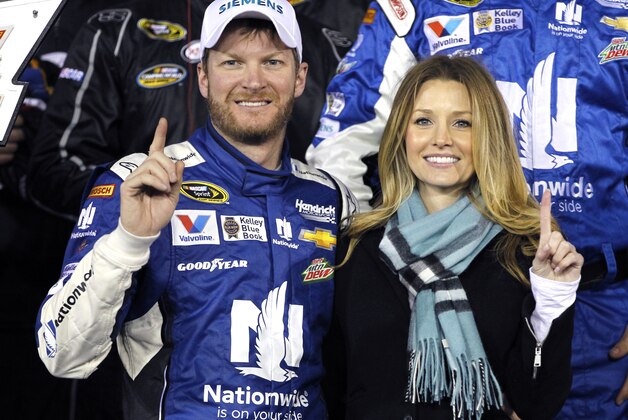 Dale Earnhardt Jr, left, poses with girlfriend Amy Reimann, right, in Victory lane after winning the first of two qualifying races for the Daytona 500 NASCAR Sprint Cup series auto race at Daytona International Speedway in Daytona Beach, Fla., Thursday, Feb. 19, 2015. (AP Photo/Terry Renna)