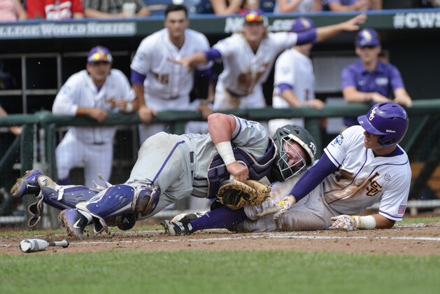 TCU catcher Evan Skoug, left, tags out LSU second baseman Jared Foster in the third inning of an NCAA College World Series baseball game at TD Ameritrade Park in Omaha, Neb., Sunday, June 14, 2015. (AP Photo/Ted Kirk)