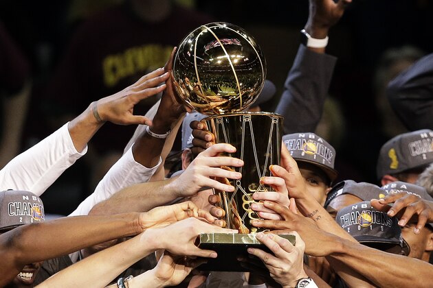 The members of the Golden State Warriors hold the championship trophy as they celebrate winning the NBA Finals against the Cleveland Cavaliers in Cleveland, Wednesday, June 17, 2015. The Warriors defeated the Cavaliers 105-97 to win the best-of-seven game series 4-2. (AP Photo/Darron Cummings)