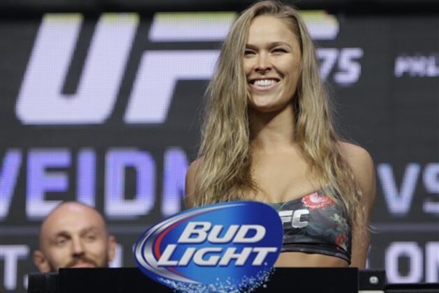 Ronda Rousey stands on the scale during a weigh-in for the UFC 175 mixed martial arts event at the Mandalay Bay, Friday, July 4, 2014, in Las Vegas. Rousey is scheduled fight Alexis Davis in a women's bantamweight title fight on Saturday in Las Vegas. (AP Photo/John Locher)